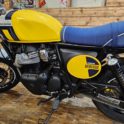 Yellow and black motorcycle with a visible brand logo on a wooden floor.