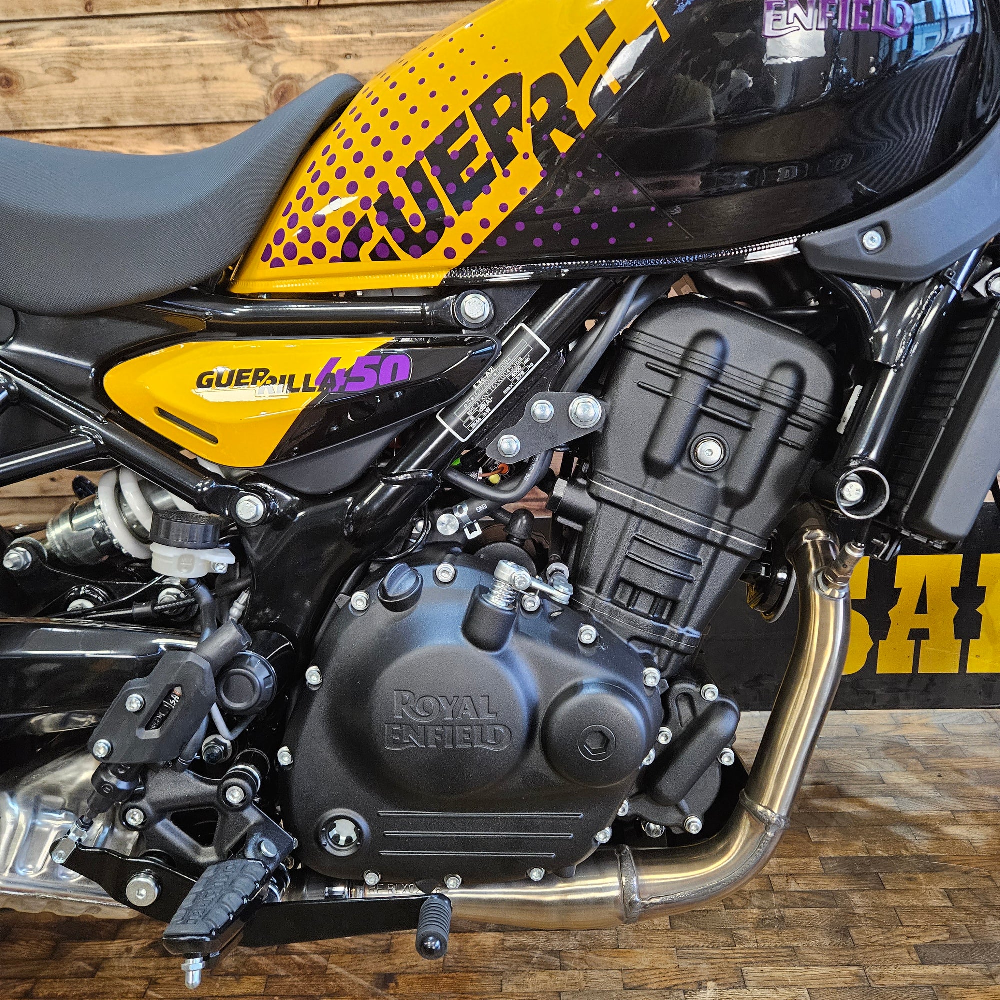 Close-up of a motorcycle engine with visible branding on a wooden background