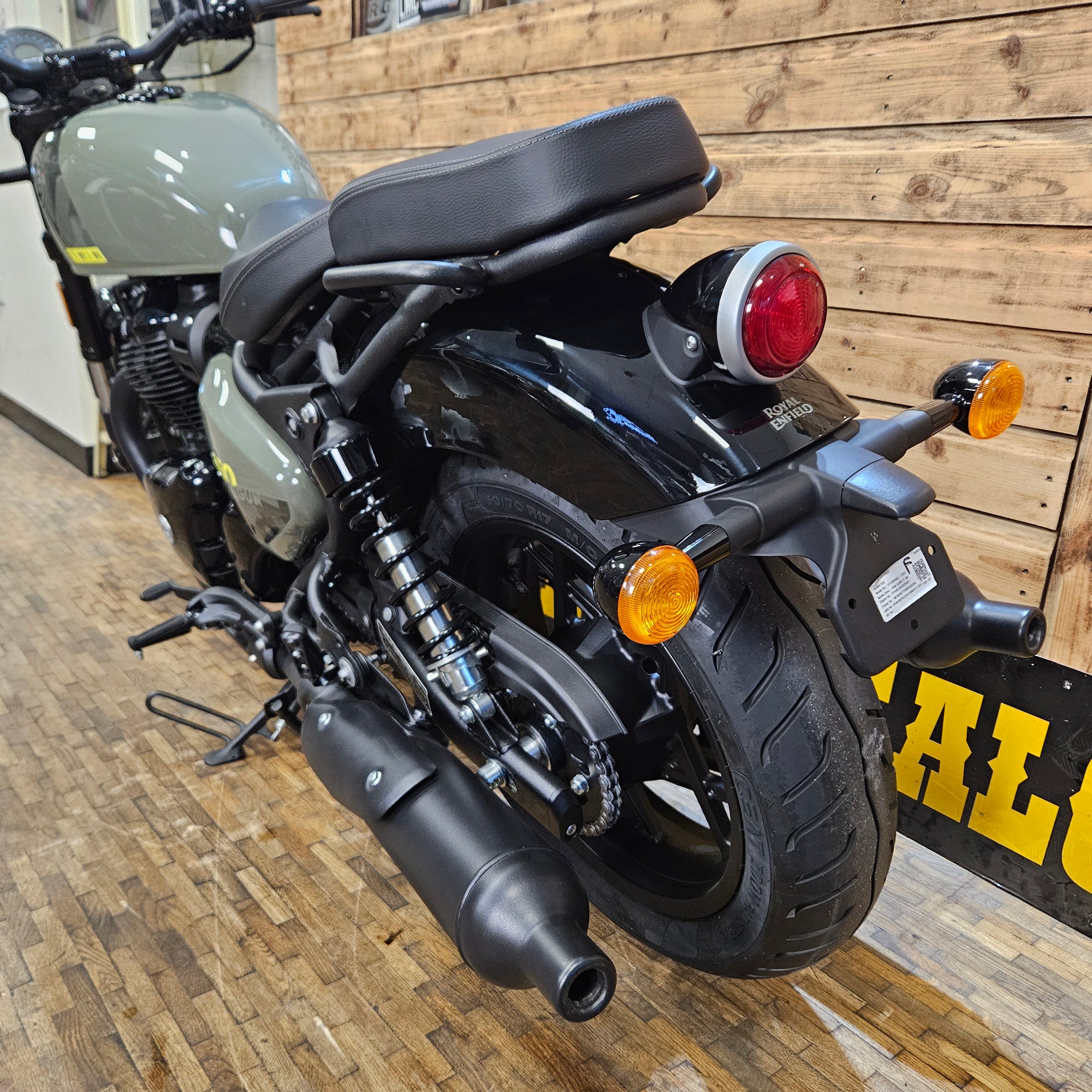 Black motorcycle with orange reflectors on a wooden floor