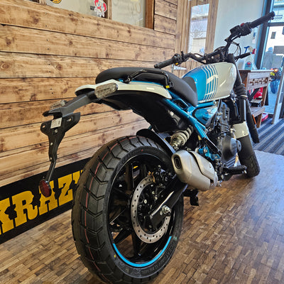 Motorcycle on a wooden floor with a brick wall background
