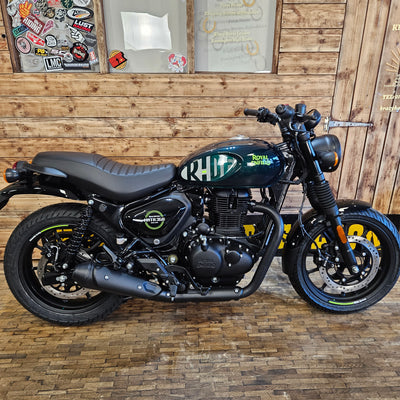 Motorcycle leaning against a wooden wall with decorative elements