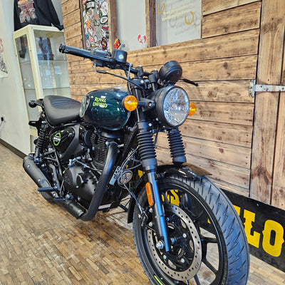 Motorcycle parked indoors with wooden floor and wall in the background