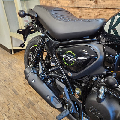 Close-up of a motorcycle with a visible brand logo on a wooden floor.