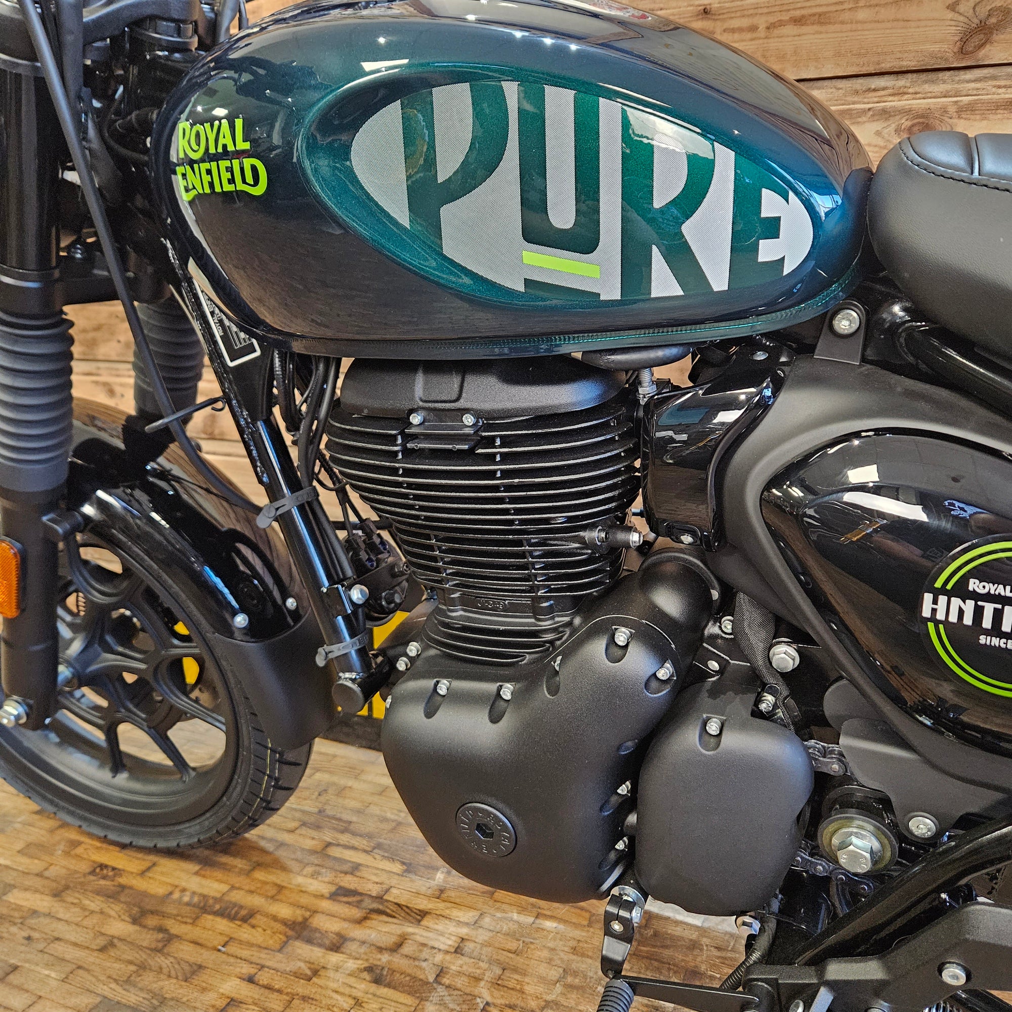 Close-up of a motorcycle with 'Pulsar' branding on a wooden floor.