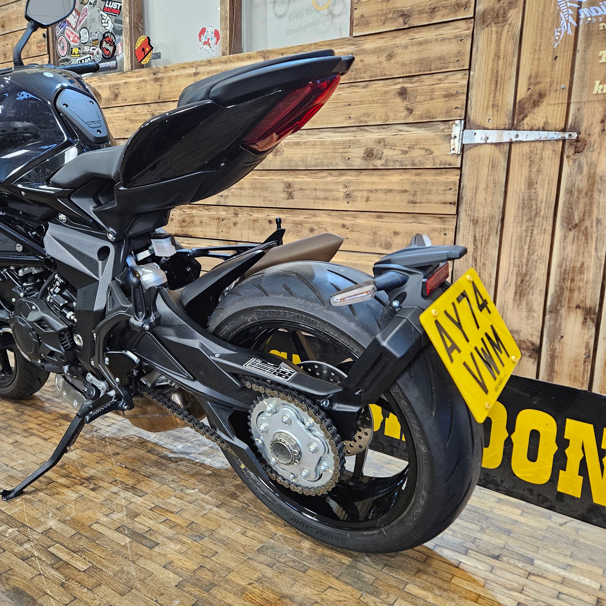 Motorcycle with a yellow license plate on a wooden floor