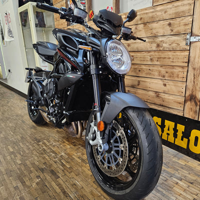 Black motorcycle indoors with wooden wall and floor
