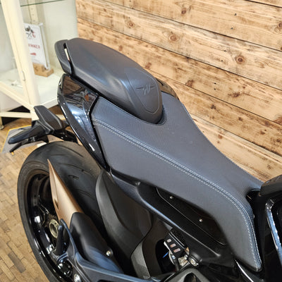 Close-up of a motorcycle seat on a wooden floor