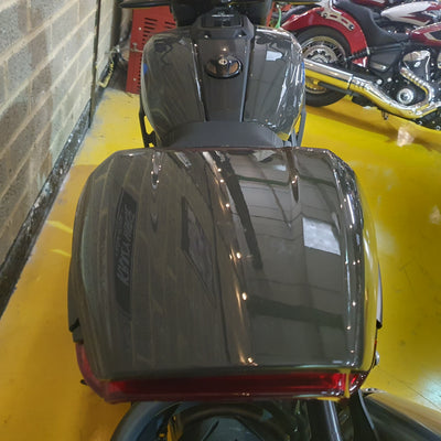 Motorcycle seat with a visible brand logo on a yellow floor.