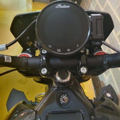 Close-up of a motorcycle handlebar with an 'Indian' brand logo on the handle.