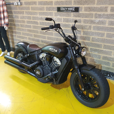 Black Indian motorcycle parked against a brick wall.