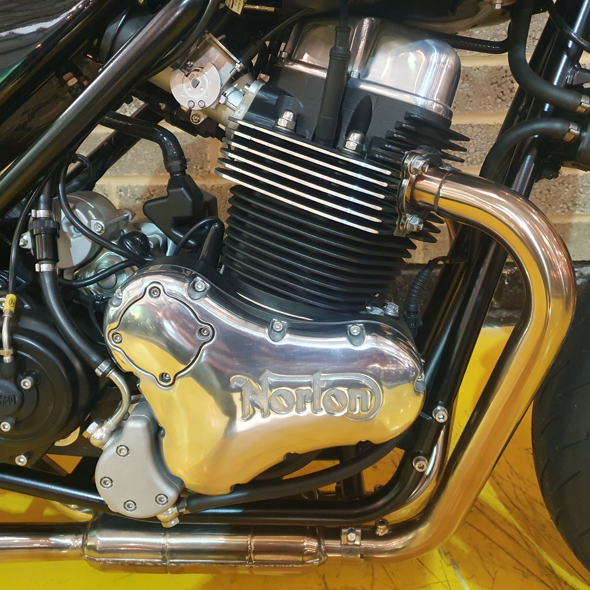 Close-up of a motorcycle engine with 'Kohon' branding on a yellow background.