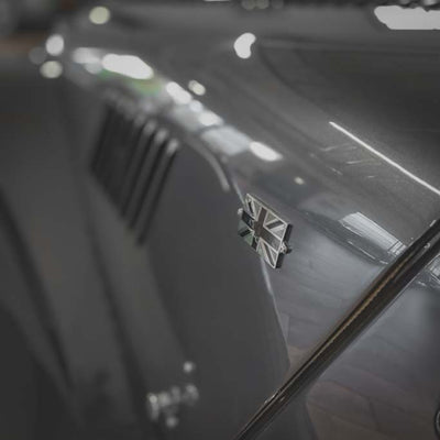 Close-up of a car door with a badge on a blurred background