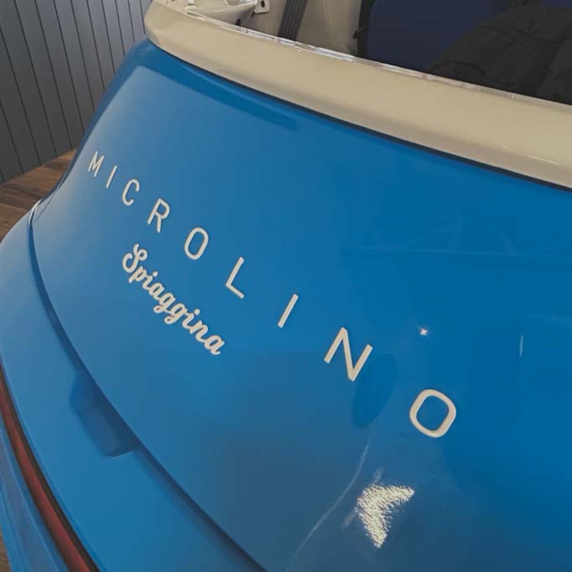 Close-up of a blue vehicle with 'MICROLINO & Spiaggina' branding.