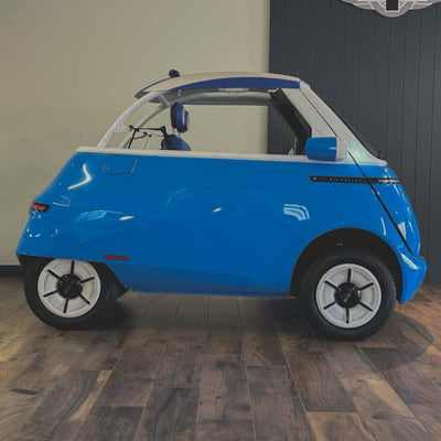 Blue and white electric vehicle on a wooden floor with a neutral background