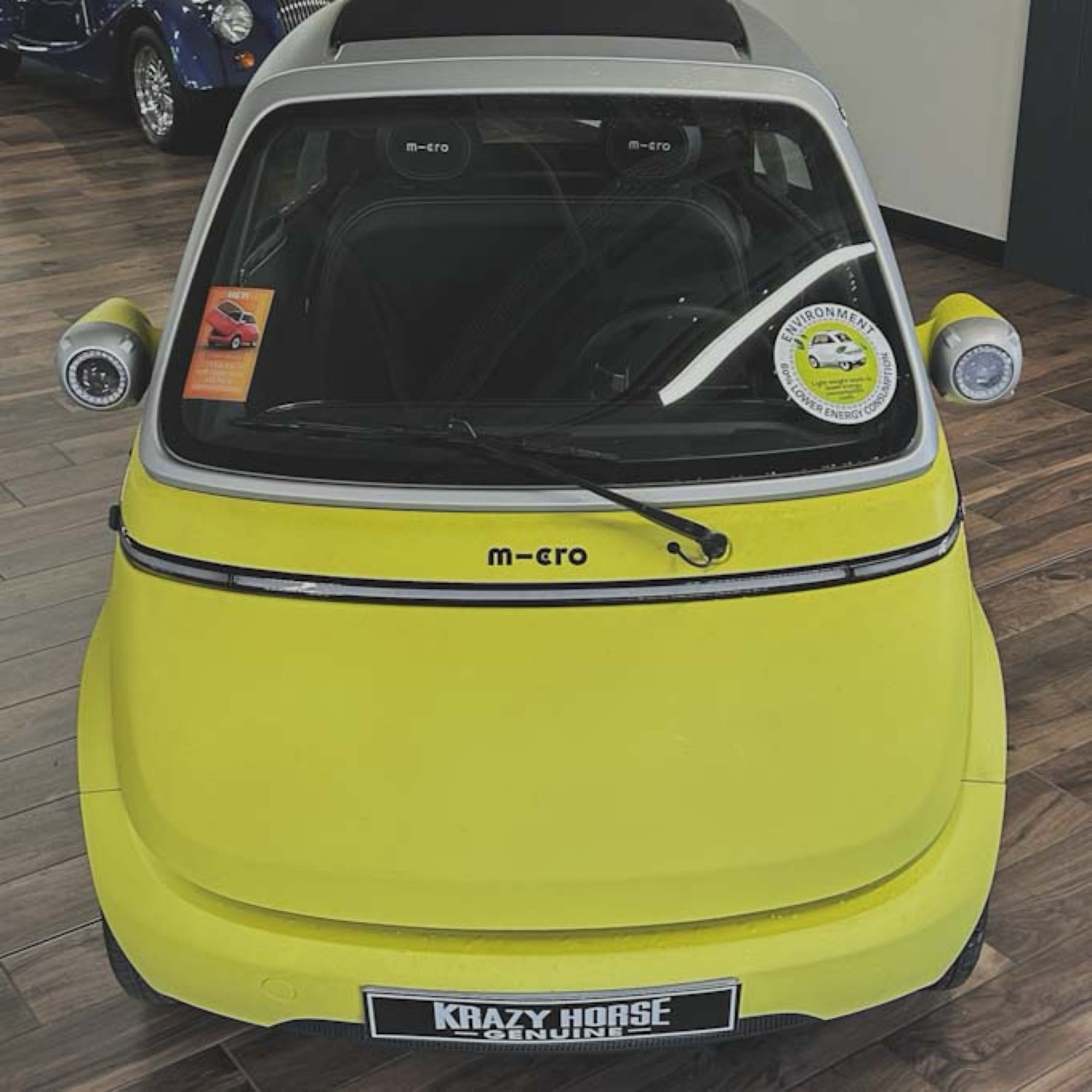 Small yellow car with visible branding on a wooden floor