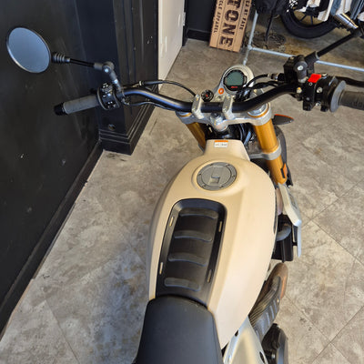 Close-up of a motorcycle handlebar with a neutral background