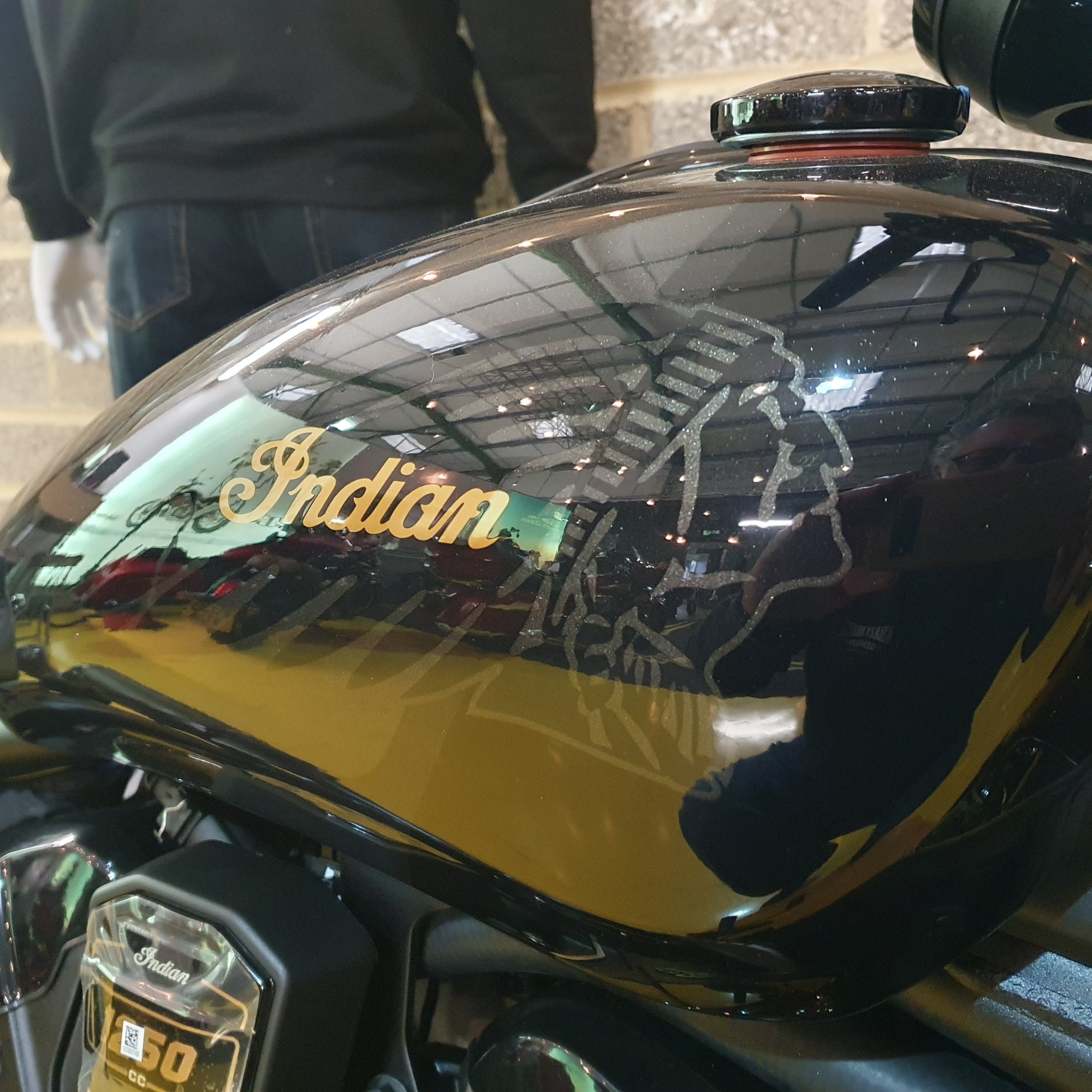 Close-up of a motorcycle fuel tank with 'Indian' branding.