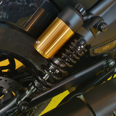 Close-up of a motorcycle suspension system with gold and black components.