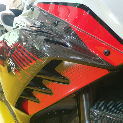 Close-up of a motorcycle's front fairing with 'R100' branding.