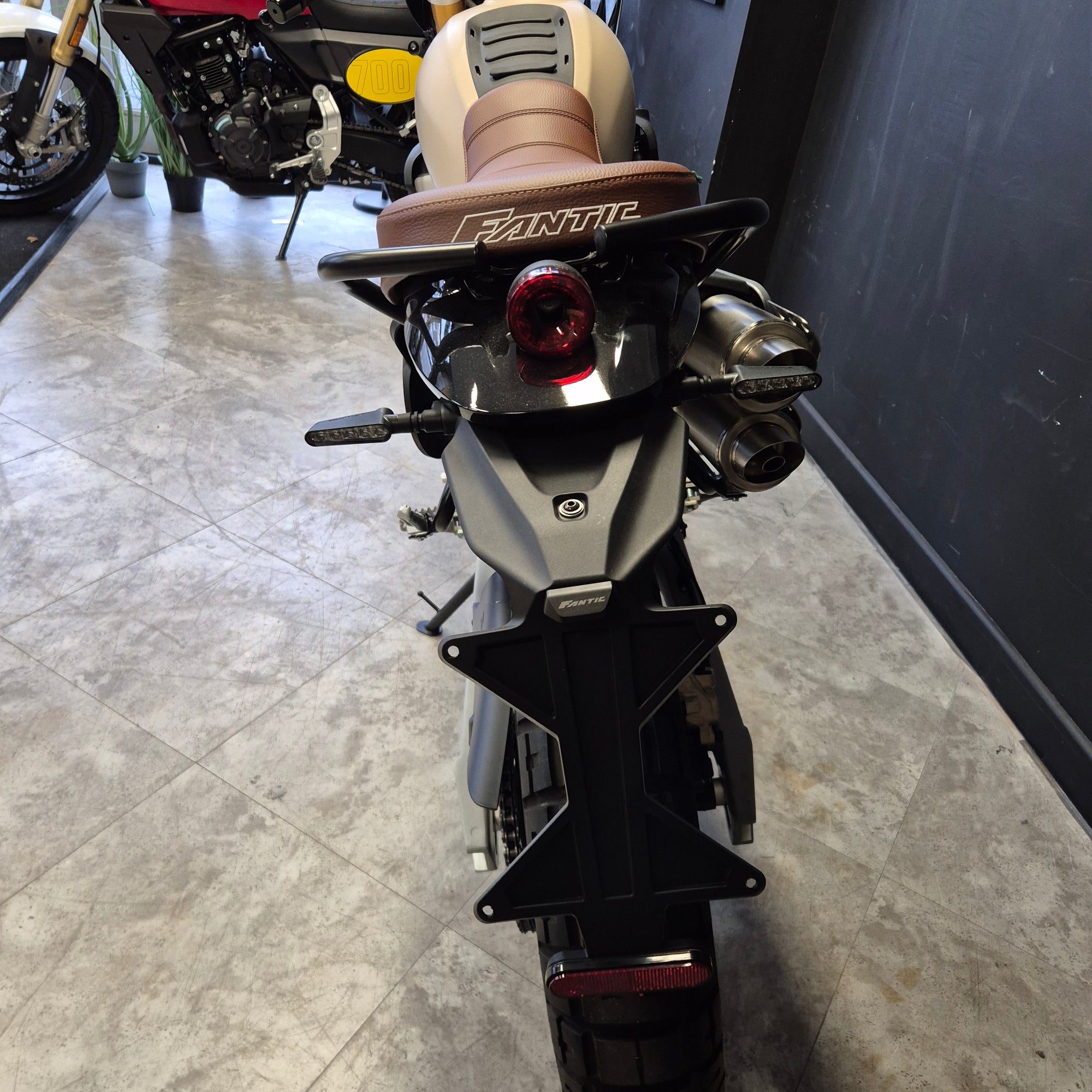 Close-up of a motorcycle suspension system on a concrete floor.
