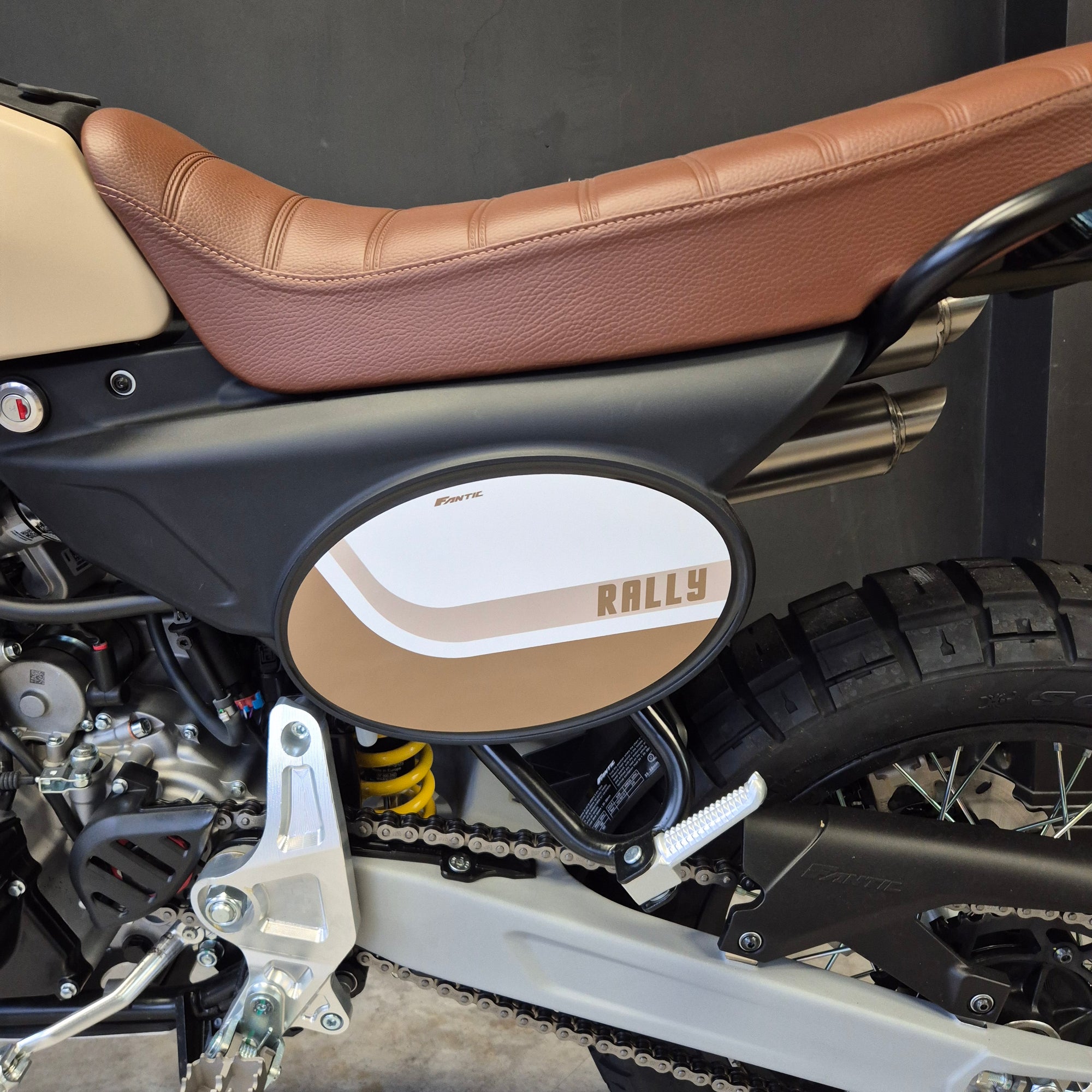 Close-up of a motorcycle with a brown seat and visible brand logo.