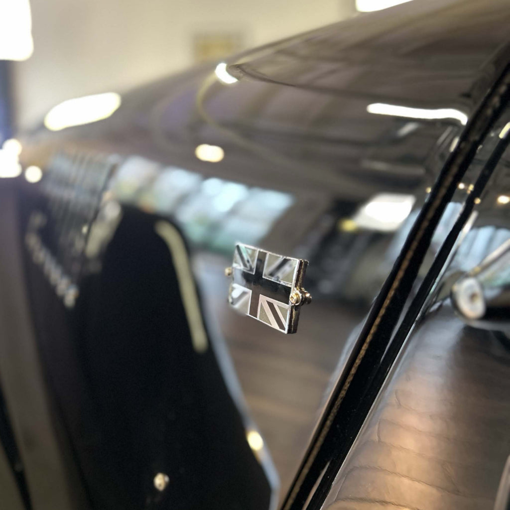 Close-up of a car emblem with a Union Jack design on a vehicle.