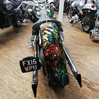 Motorcycle with colorful design and license plate in a showroom setting