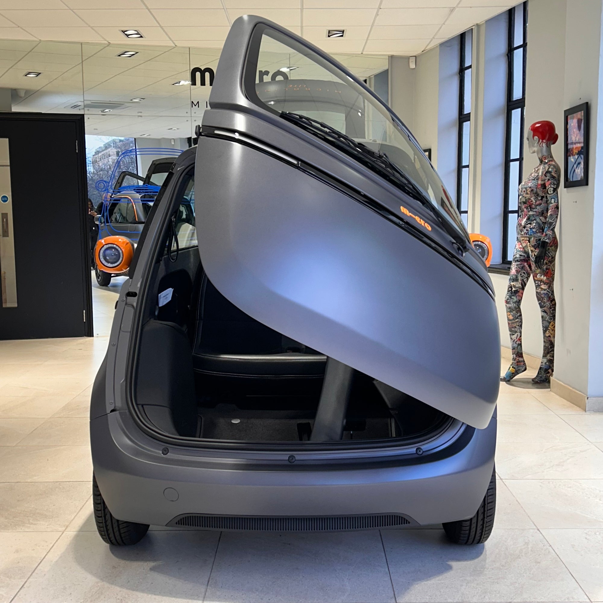 Modern car with open rear door in a showroom setting