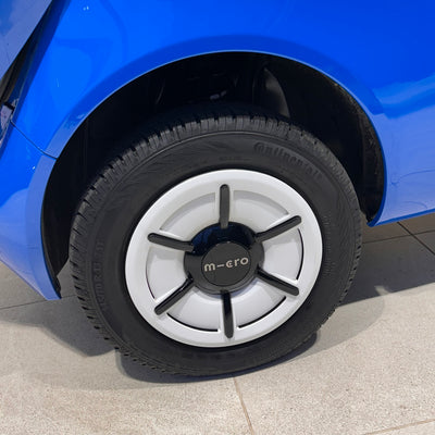 Close-up of a blue car tire with a white rim featuring the 'micro' brand.