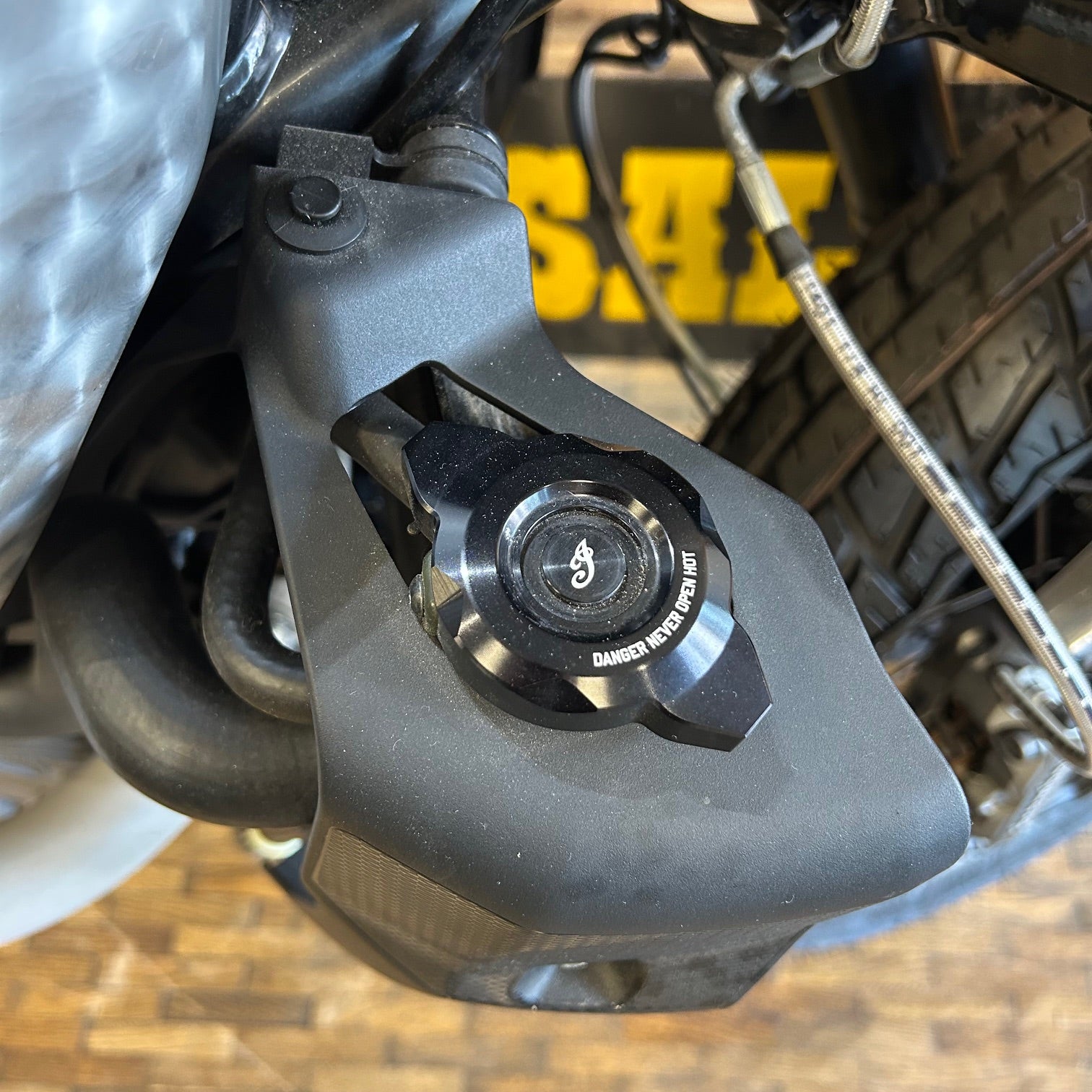 Close-up of a motorcycle brake lever with 'Dainese' branding.