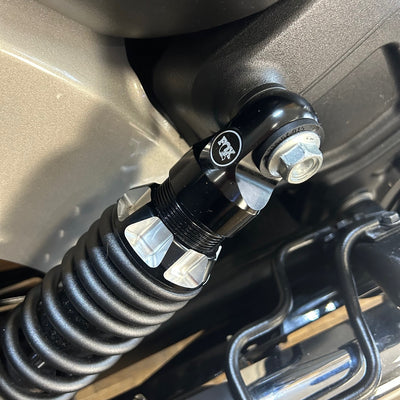 Close-up of a black coiled cable attached to a vehicle's hitch receiver.