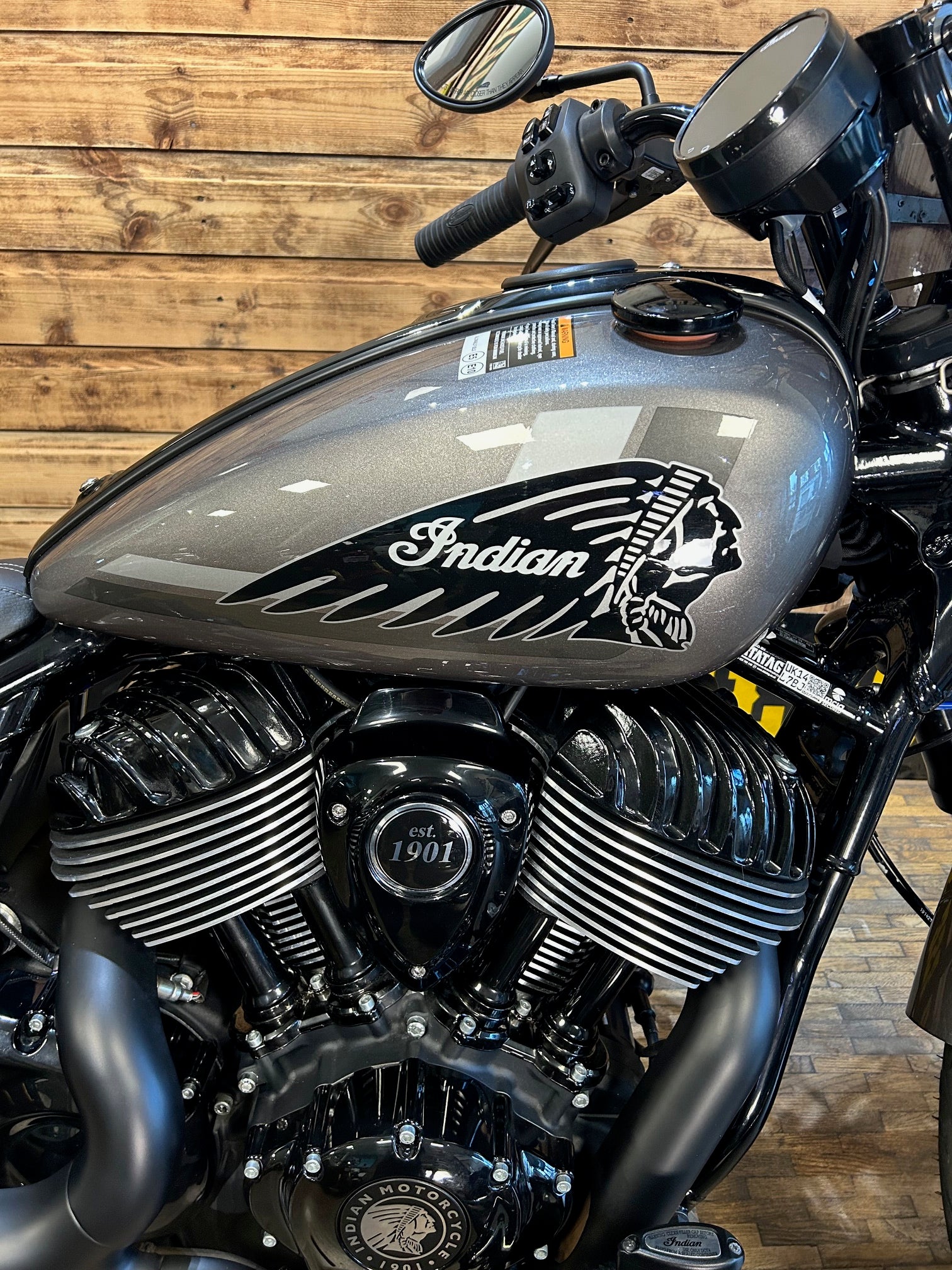 Close-up of an Indian motorcycle engine and fuel tank on a wooden background