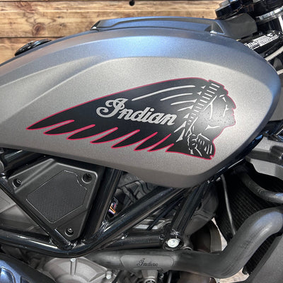 Close-up of a motorcycle with an Indian logo on a wooden background