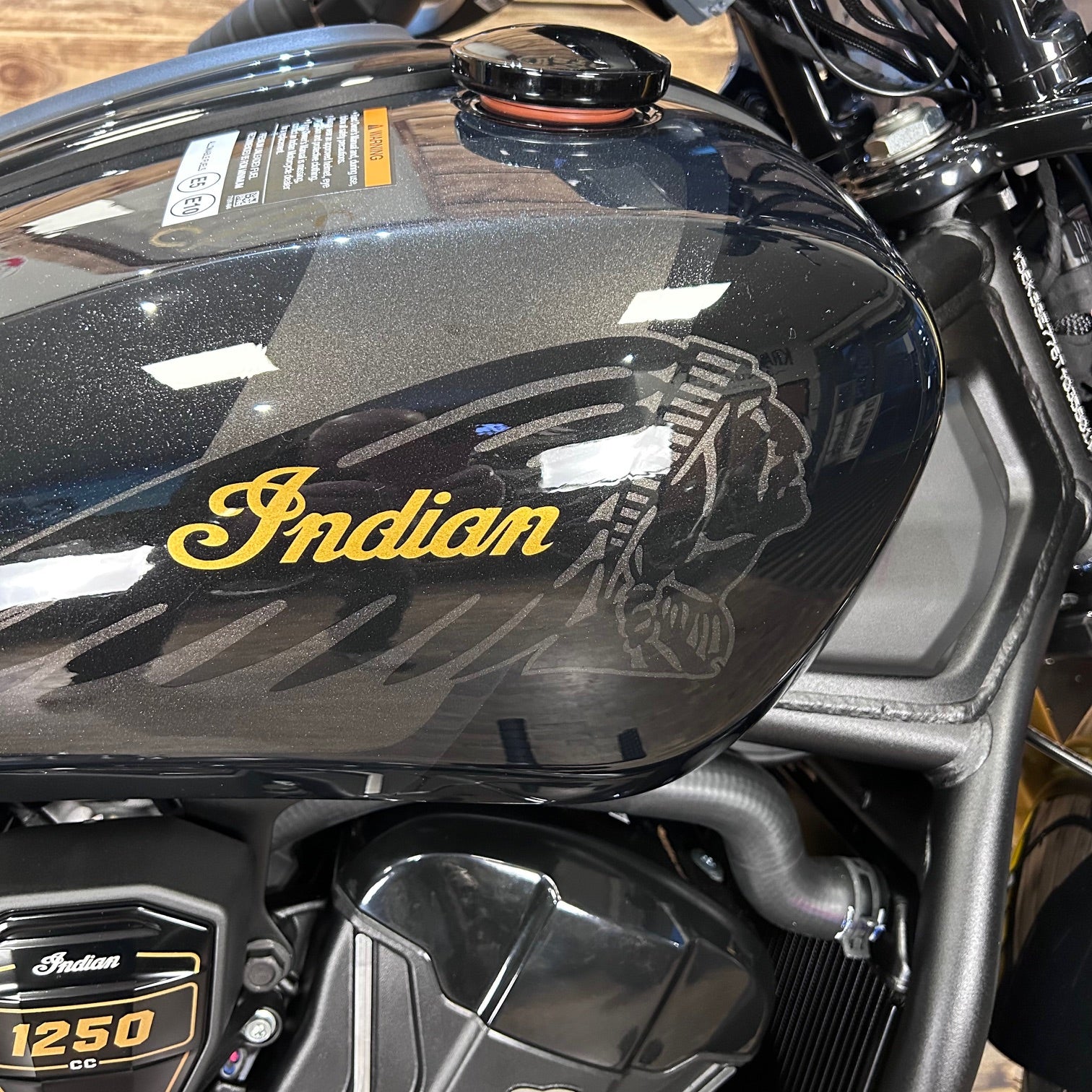 Black motorcycle fuel tank with 'Indian' logo and '1250'cc text.