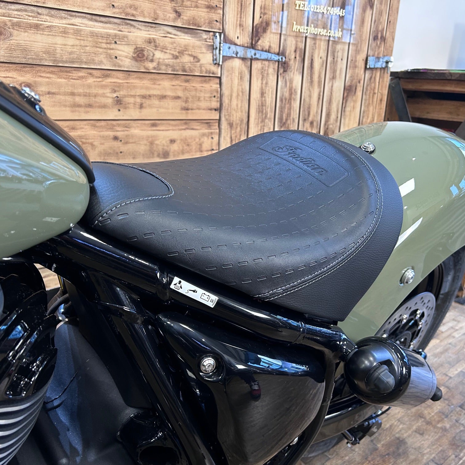 Close-up of a motorcycle seat with a wooden background