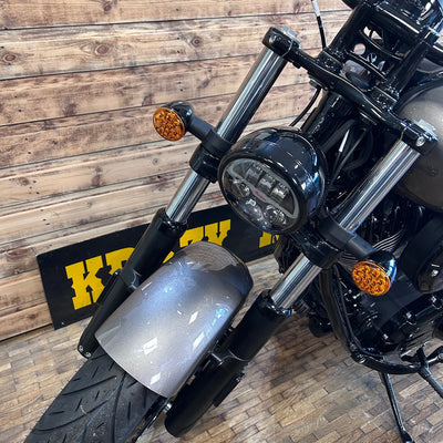 Close-up of a motorcycle with a wooden floor background