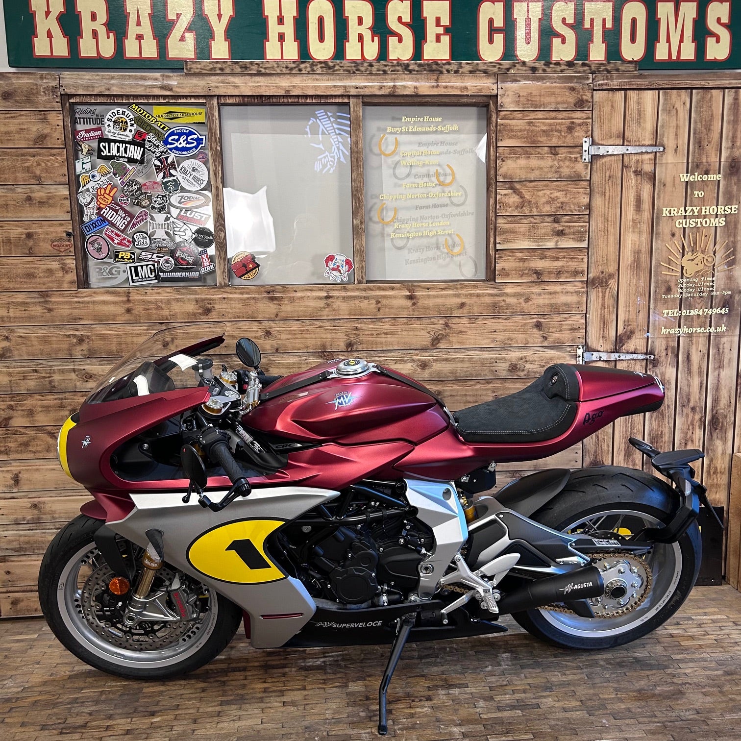 Motorcycle with a number 1 on a wooden wall with 'Krazy Horse Customs' sign