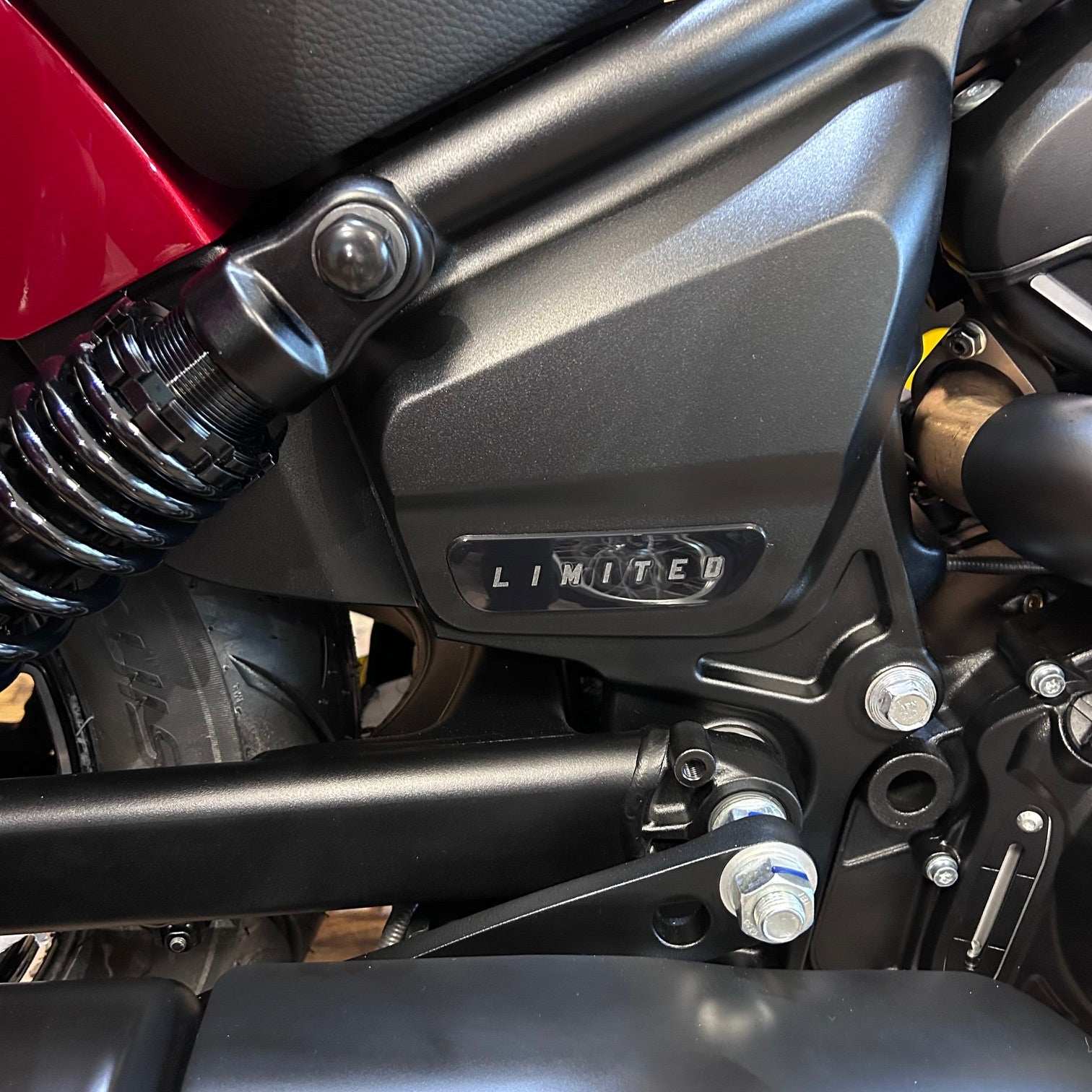 Close-up of a motorcycle with 'Limited' branding on a black and red background