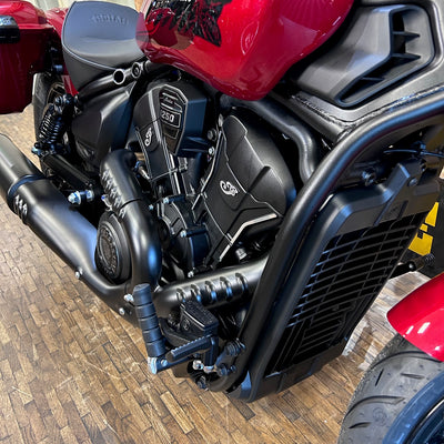Close-up of a motorcycle engine and exhaust on a wooden floor