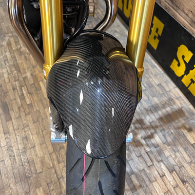 Carbon fiber exhaust on a motorcycle with gold frame
