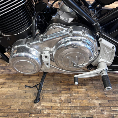 Motorcycle engine with a brand logo on a wooden floor