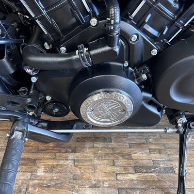 Close-up of a motorcycle engine with 'Indian Motor' branding on a wooden floor.