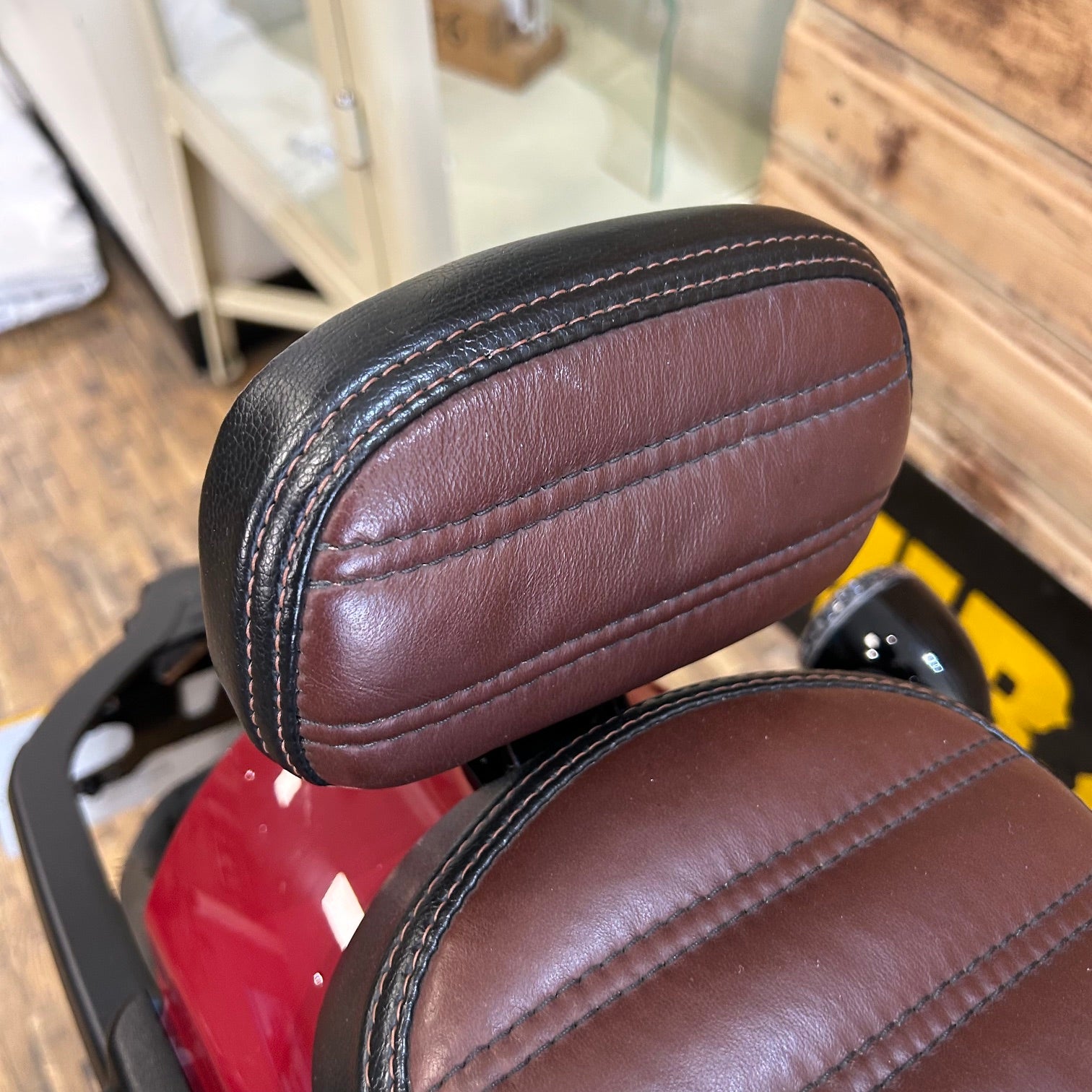 Brown leather seat of a vehicle with a blurred indoor background