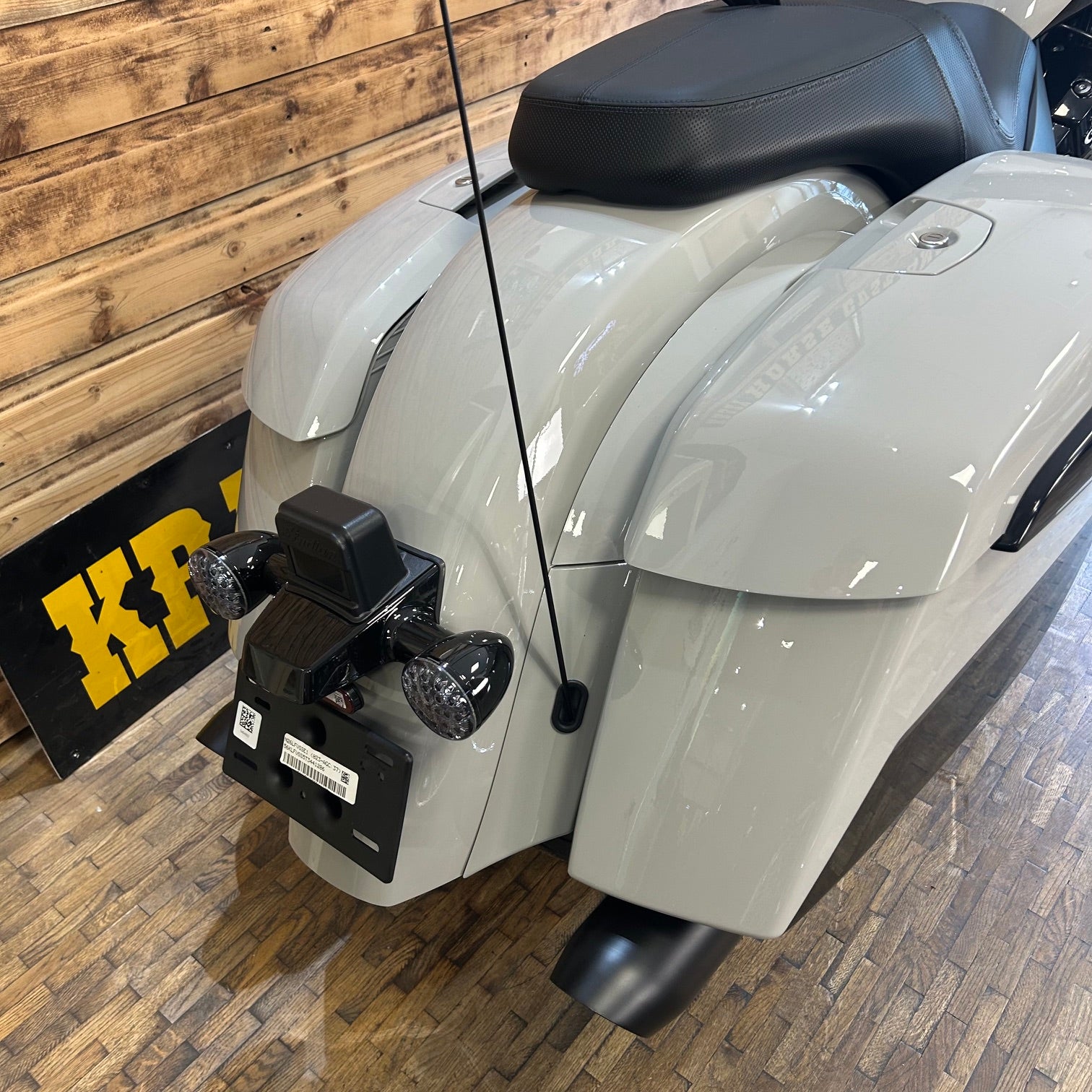 Gray motorcycle with a visible brand logo on a wooden floor