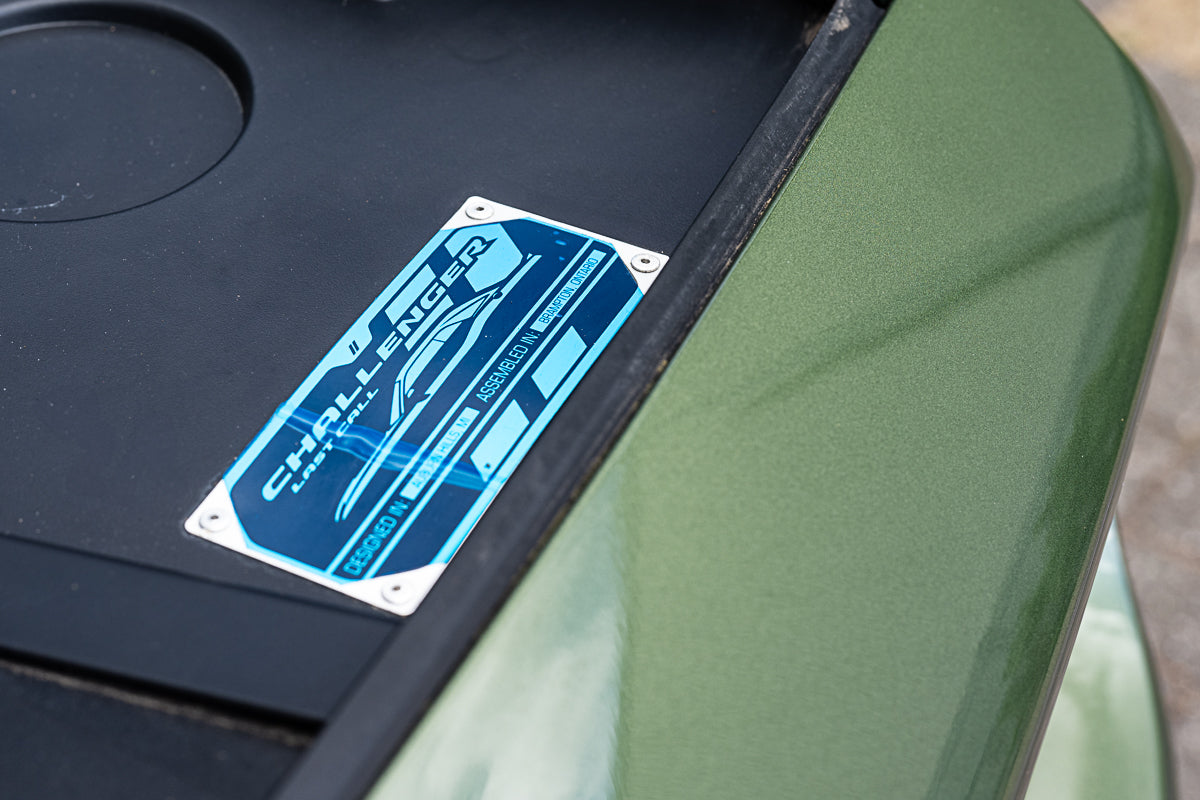 Close-up of a green vehicle with a blue 'Challenge' logo on a black background