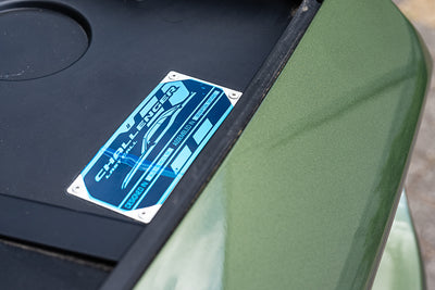 Close-up of a green vehicle with a blue 'Challenge' logo on a black background