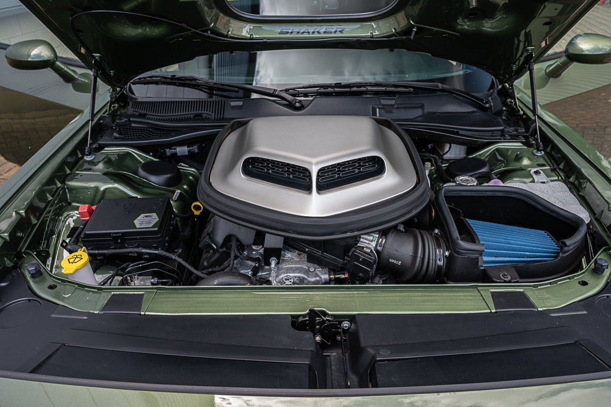 Car engine compartment with open hood showing engine and components.