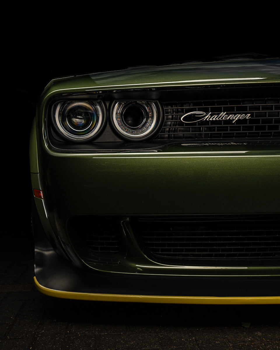 Front view of a green Dodge Challenger car on a black background