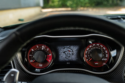 Car dashboard with red and black gauges and a digital display.