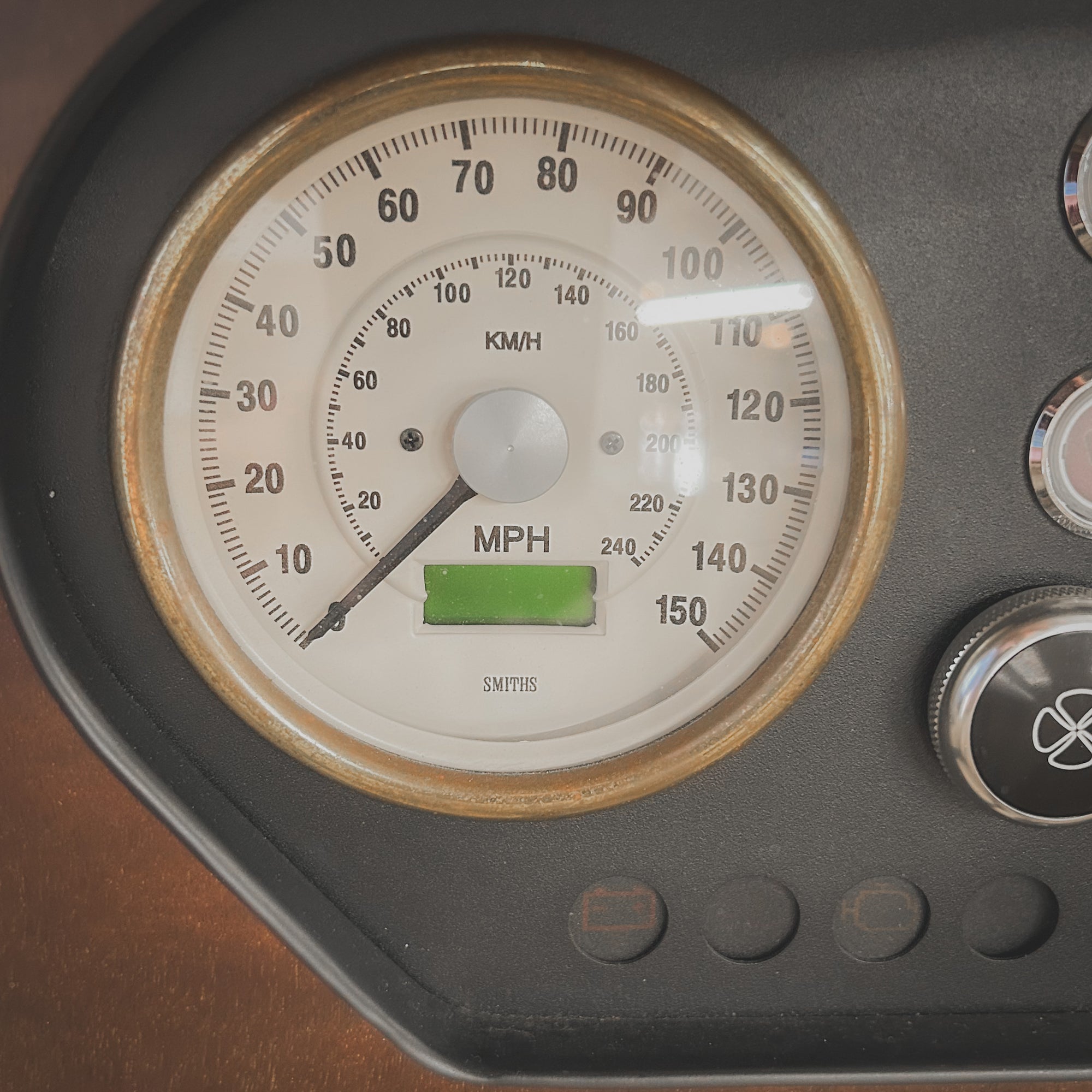 Close-up of a vintage-style speedometer with a brown border.